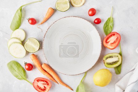 Aesthetic, vegan, organic, healthy food, plant-based diet concept. White plate on the table among vegetables and fruits .