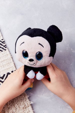 Child plays with adorable mickey mouse stuffed toy - cute and classic.
