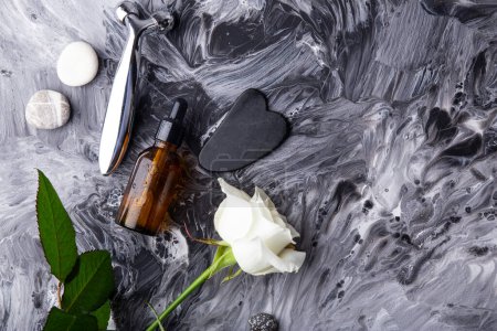 Minimalistische Hautpflege mit Massagerolle, Serum, Gua-sha auf flüssigem Kunsthintergrund.
