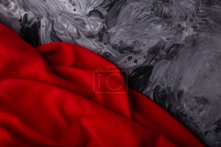 Contrast with red fabric on dramatic gray swirl background.