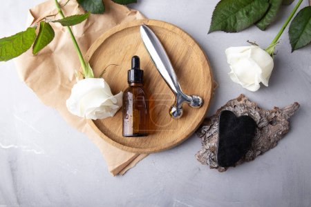 Photo for Self care composition with facial serum, gua sha, facial roller. Holistic beauty arrangement with roses. - Royalty Free Image