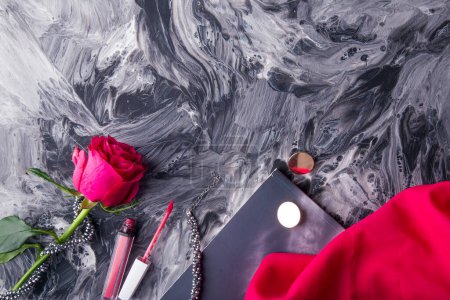 Ensemble cosmétique élégant avec rose rose sur peinture abstraite dynamique. Arrière-plan art fluide.