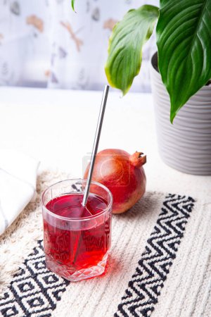 Juice Aesthetics - Pomegranate Refreshment. Natural healthy juice near indoor plant.
