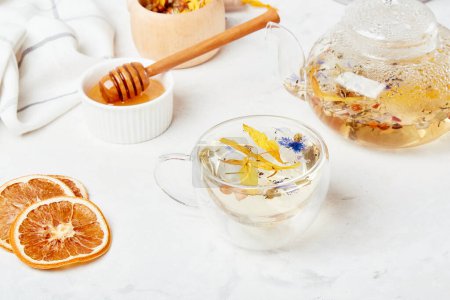 Elixir de bienestar alpino, té natural en taza de vidrio. Mezcla de montaña orgánica - concepto de infusión herbal refrescante.