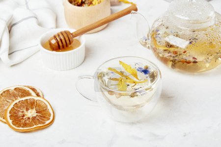 Téléchargez les photos : Elixir bien-être alpin, thé naturel dans une tasse en verre. Mélange de montagne biologique - concept rafraîchissant d'infusion à base de plantes. - en image libre de droit
