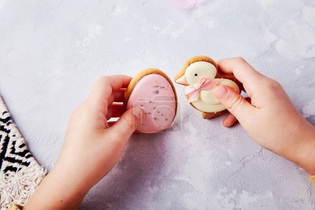 Osterkekse in den Händen eines Kindes, die schmackhafte Traditionen festhalten.