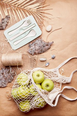 Eco-friendly, zero waste, sustainable lifestyle background with cutlery, apples, tree bark, pebbles on crafting paper
