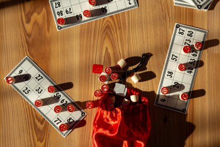 Brettspielspaß mit Vintage-Bingo-Set und roter Tasche im Sonnenlicht.