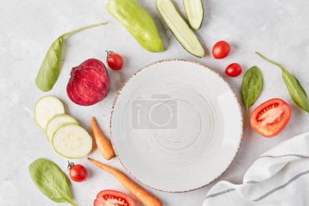 Vegan, organic, healthy food, plant-based diet concept. White plate on the table among vegetables and fruits close up. top view, copy space.