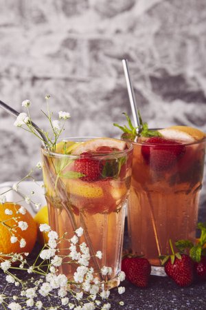 Estético verano pomelo brillante, bebida cóctel de fresa, decorado por gypsophila. Healthy refrescante desintoxicación cóctel vitaminizado.