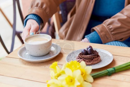 Téléchargez les photos : Doux et floral - profiter d'un moment café avec cappucino, dessert et jonquilles. - en image libre de droit