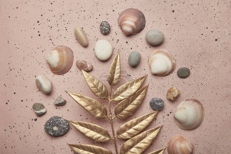 Beach elegance with golden leaves, and shells on a summer background.