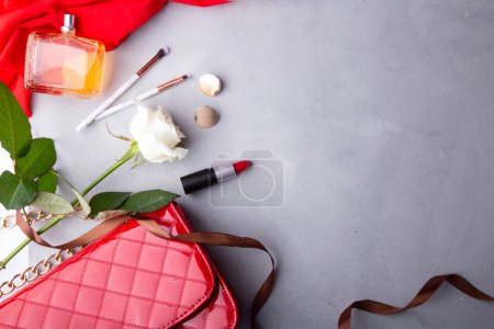 Luxuriöse Schönheit und stilvolles Arrangement mit Parfüm und Rosen. Rote Akzente, femininer Hintergrund.