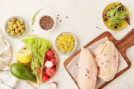 Menu pour Paléo, concept de régime FODMAP. Fruits, légumes, olives, viande de poulet, légumes verts sur planche à découper en bois