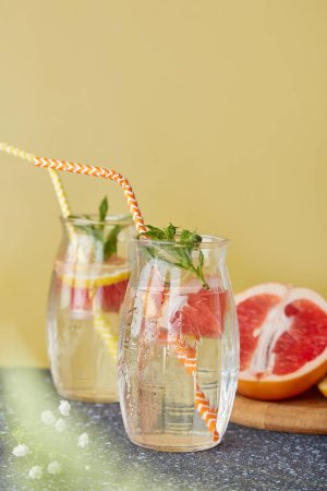 Summer refreshing detox cold cocktails with citrus fruits. Aesthetic trendy non - alcoholic beverage. Vertical photo.
