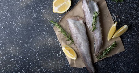 Culinary presentation of uncooked hake with aromatic herbs, suited for gourmet cooking tutorials or menu imagery. Extra wide banner