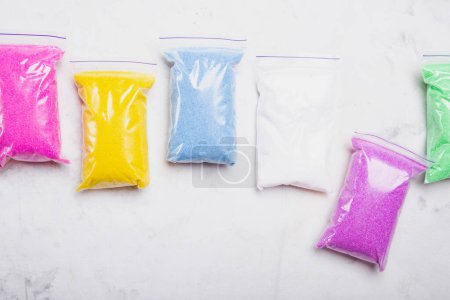Array of bright colored craft sand in sealable bags for creative projects