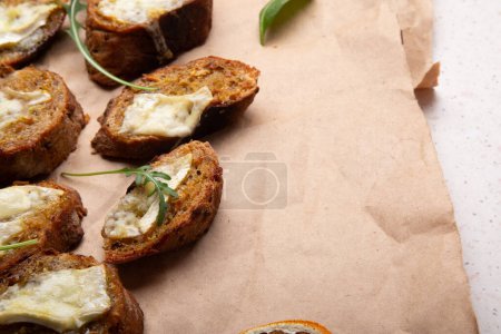 Rustic cheese on toast arrangement with a touch of green garnish. Copy space. Comfort food.