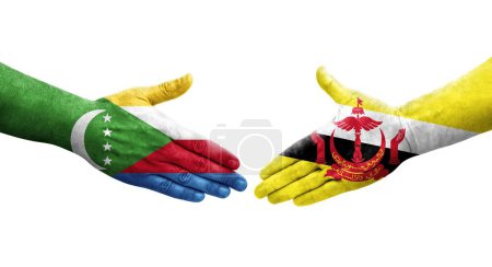 Photo for Handshake between Brunei and Comoros flags painted on hands, isolated transparent image. - Royalty Free Image