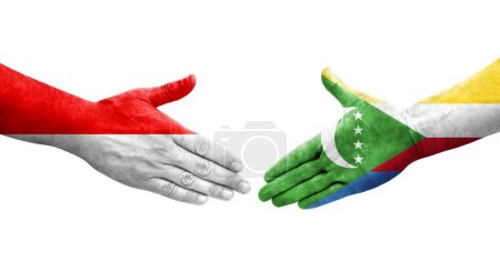 Photo for Handshake between Comoros and Indonesia flags painted on hands, isolated transparent image. - Royalty Free Image