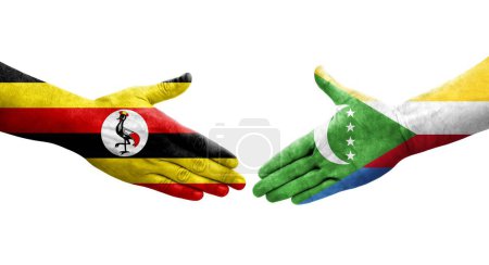Photo for Handshake between Comoros and Uganda flags painted on hands, isolated transparent image. - Royalty Free Image