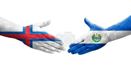 Poignée de main entre le Salvador et les îles Féroé drapeaux peints sur les mains, image transparente isolée.