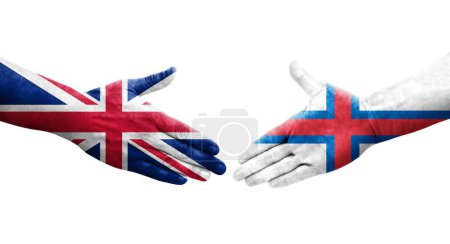 Poignée de main entre les îles Féroé et le Royaume-Uni drapeaux peints sur les mains, image transparente isolée.