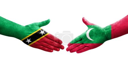 Photo for Handshake between Maldives and Saint Kitts and Nevis flags painted on hands, isolated transparent image. - Royalty Free Image