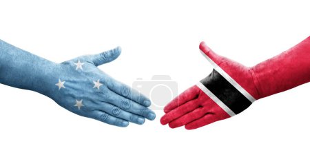 Téléchargez les photos : Poignée de main entre les drapeaux Micronésie et Trinité Tobago peints sur les mains, image transparente isolée. - en image libre de droit