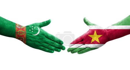 Photo for Handshake between Suriname and Turkmenistan flags painted on hands, isolated transparent image. - Royalty Free Image