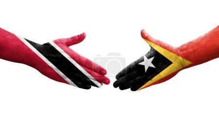 Téléchargez les photos : Poignée de main entre les drapeaux Timor Leste et Trinité Tobago peints sur les mains, image transparente isolée. - en image libre de droit
