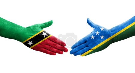 Photo for Handshake between Solomon Islands and Saint Kitts and Nevis flags painted on hands, isolated transparent image. - Royalty Free Image