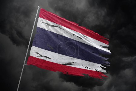 Téléchargez les photos : Thaïlande déchiré drapeau sur fond de ciel sombre. - en image libre de droit