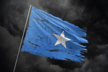 Somalia zerrissene Flagge auf dunklem Himmel.