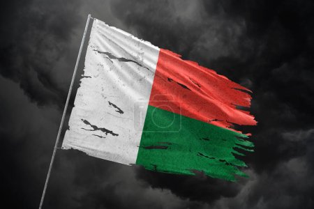 Téléchargez les photos : Madagascar déchiré drapeau sur fond de ciel sombre. - en image libre de droit