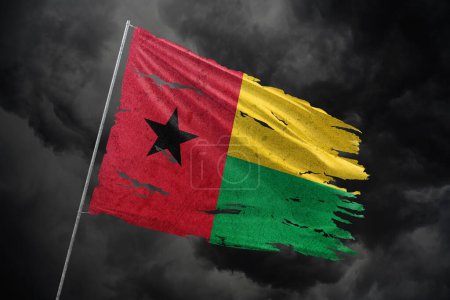Photo for Guinea-Bissau torn flag on dark sky background. - Royalty Free Image