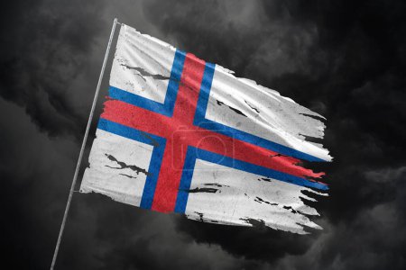 Faroe Islands torn flag on dark sky background.