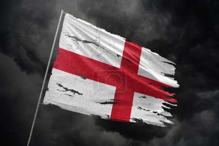 England torn flag on dark sky background.