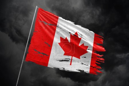 Téléchargez les photos : Drapeau déchiré du Canada sur fond de ciel sombre. - en image libre de droit