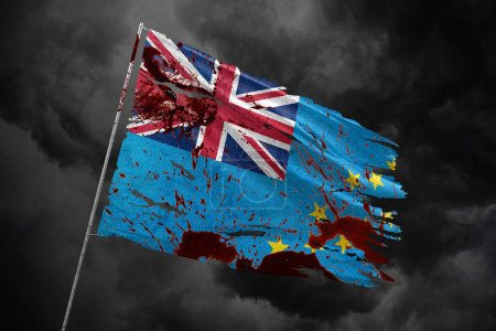 drapeau déchiré Tuvalu sur fond de ciel sombre avec des taches de sang.