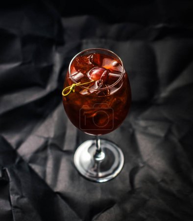 Glas eines Cocktails mit Eiswürfeln auf dunklem Hintergrund