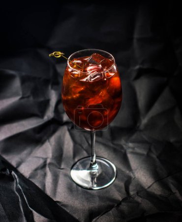 Glas eines Cocktails mit Eiswürfeln auf dunklem Hintergrund