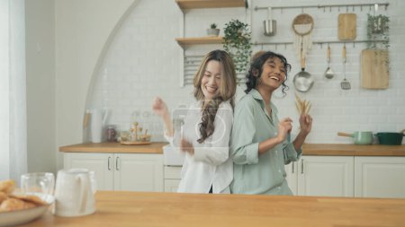 Concepto de vacaciones de 4k Resolución. Mujeres asiáticas bailando juntas en la cocina. Las mujeres jóvenes están en una relación de amor lésbico mutuo.