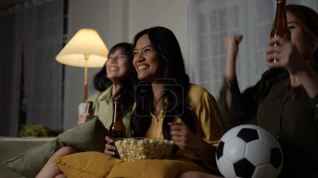 Photo for Holiday concept of 4k Resolution. A group of Asian women watching a soccer match broadcast together at home. Fun and exciting leisure activities. - Royalty Free Image
