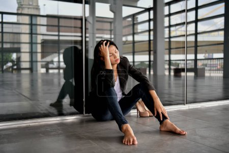Téléchargez les photos : Femme d'affaires asiatique est stressée dans la ville. Elle se sent déprimée par sa vie en faillite. - en image libre de droit