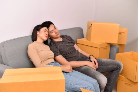 Photo for Asian man and woman couple handling parcels in the house. They fell asleep because they were tired from moving house. - Royalty Free Image