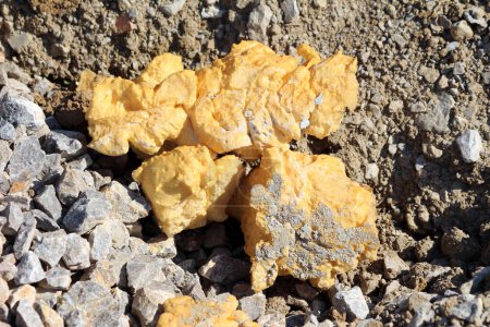 Chunks of used old Polyurethane foam or PU foam specialist material used for thermal insulation based on polyurethane chemistry left on gravel and stones at local construction site on warm sunny summer day