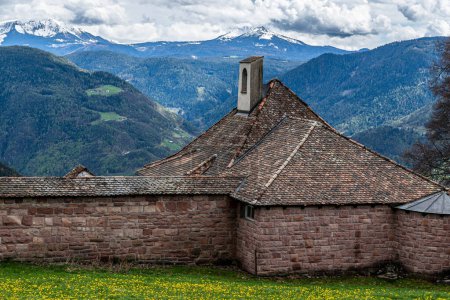 Foto de Muralla de ladrillo entre exuberantes prados verdes y montañas cubiertas de nieve en el Tirol del Sur - Imagen libre de derechos