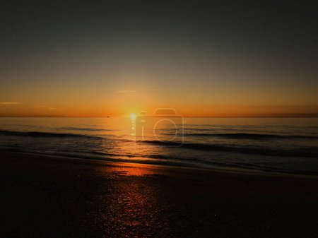Sunrise on the Mediterranean coast of southern France, flat sea, small waves near Sete