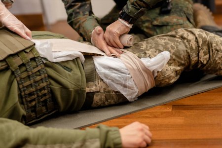 Training dressing of the wounded leg of a Ukrainian fighter, close-up. High quality photo